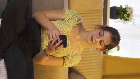 Vertical-video-of-Young-woman-texting-sadly-with-her-boyfriend.